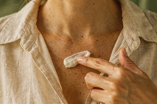 Woman applying whipped beef tallow body butter to her collarbone