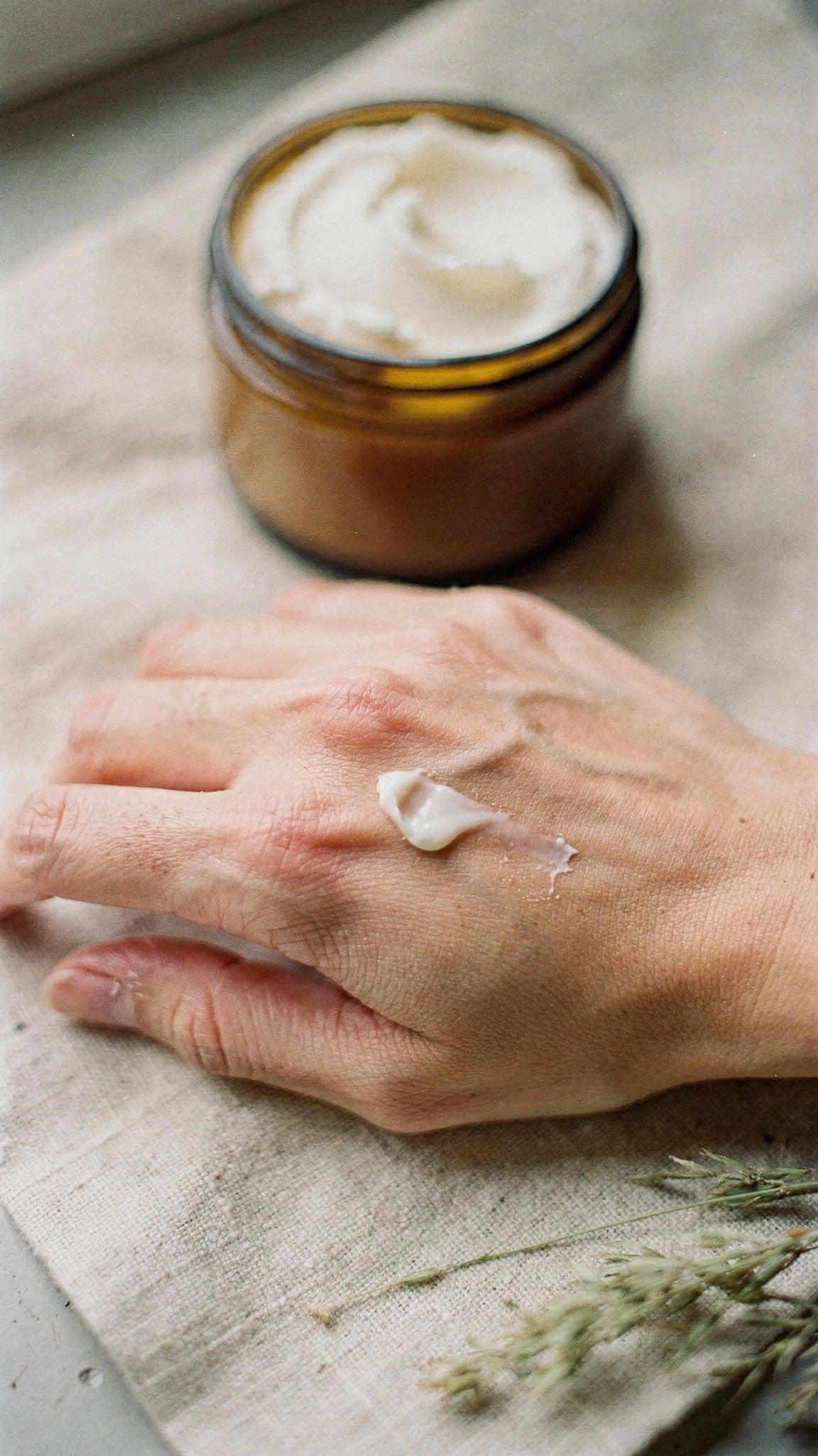Whipped tallow body butter for dry skin worked into the back of a hand.