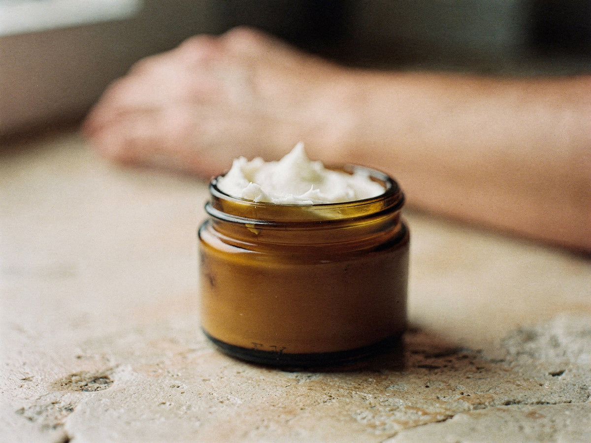 Thick tallow body butter for eczema-prone skin, holding a peak on a spatula.