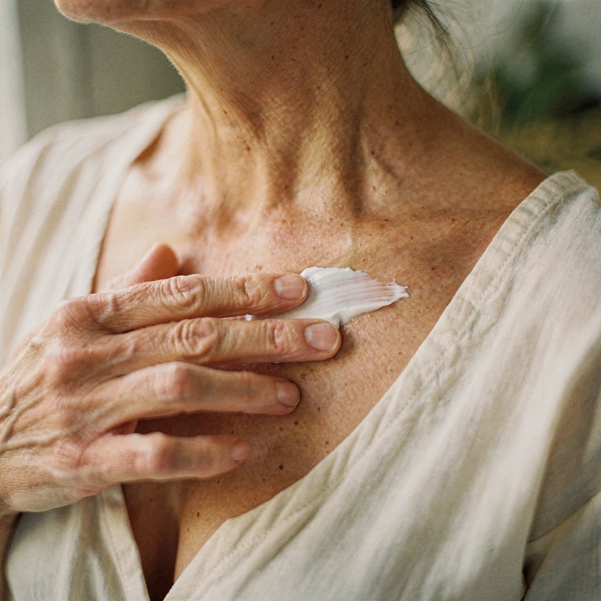 Tallow balm for aging skin pressed along the neck and collarbone.